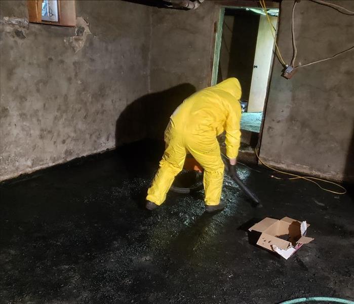 SERVPRO technician with extraction equipment on a dirty floor