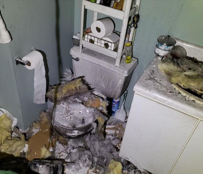 Toilet and sink with charred insulation and debris