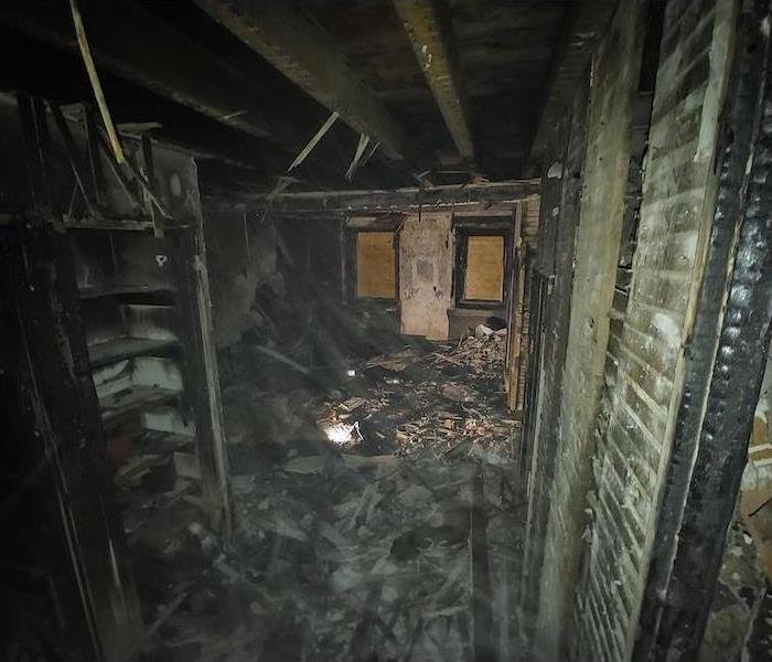 Interior of home with fire damage and charred debris