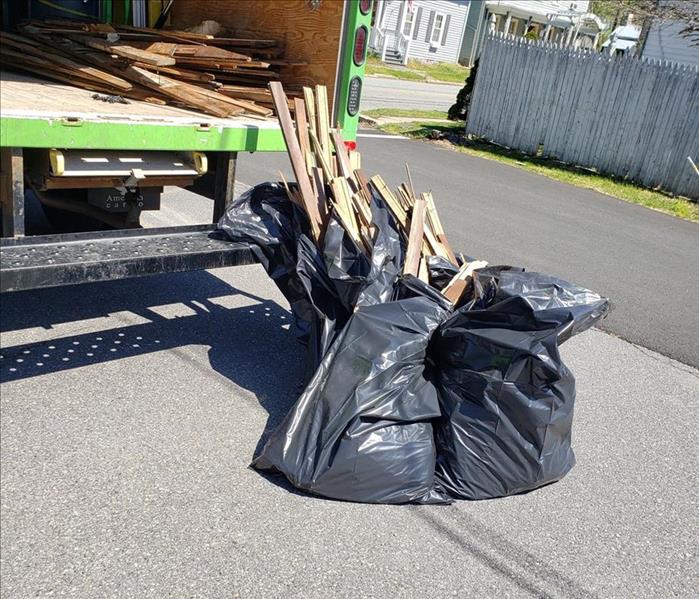 Bags of debris by a SERVPRO vehicle