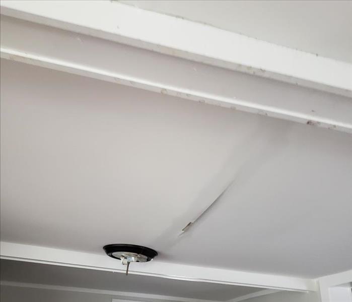 Ceiling with light fixture and water stain